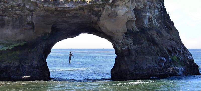 Stand up paddle boarder at Natural Bridges
